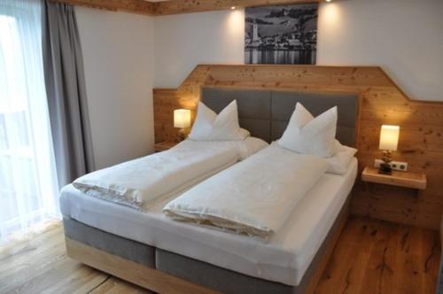 a bedroom with two beds with white sheets and pillows at Altroiterhof in St. Wolfgang