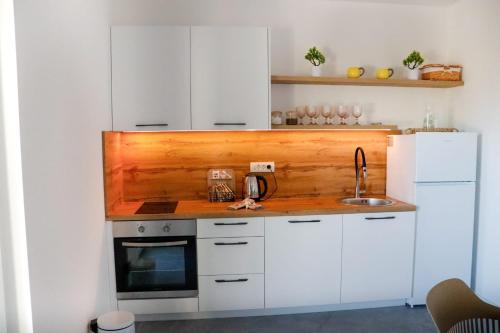 a kitchen with white cabinets and a sink at Z House kuća za odmor in Blagaj