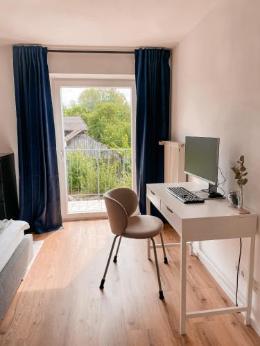 a room with a desk with a computer and a window at Your Home Base - Vacation & Work close to Munich in Dachau