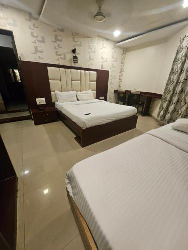 a hotel room with two beds in a room at Prime Hotel Addore Palácée - Near Mumbai Airport , Visa Consultant , Jio World Convention Centre BKC in Mumbai