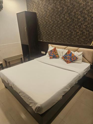a bed with two pillows on it in a room at Prime Hotel Addore Palácée - Near Mumbai Airport , Visa Consultant , Jio World Convention Centre BKC in Mumbai