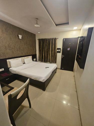 a bedroom with a bed and a chair in it at Prime Hotel Addore Palácée - Near Mumbai Airport , Visa Consultant , Jio World Convention Centre BKC in Mumbai