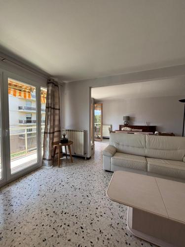 un salon avec un canapé et une grande fenêtre dans l'établissement Aix en Provence, dans grande résidence arborée, appartement de 80m2, à Aix-en-Provence