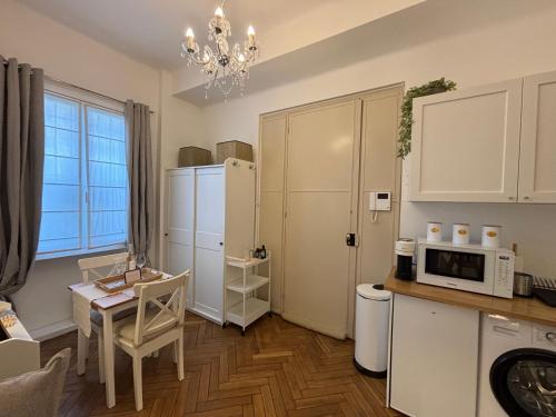 une cuisine avec une table et un réfrigérateur blanc dans l'établissement Cosy Studio Hyper Centre-Ville, à Nice