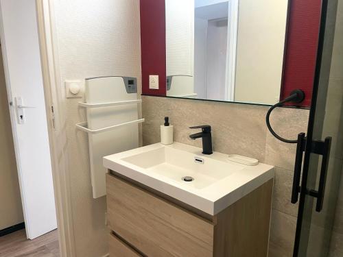 une salle de bain avec un lavabo et un réfrigérateur dans l'établissement ღ Le Petit Jars 2 Chambres Lumineux & Cosy, à La Rochelle