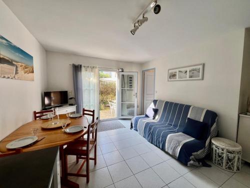 un salon avec une table et un canapé dans l'établissement 100 L'Orneau - Plain-pied avec terrasse, idéalement situé, à Saint-Martin-de-Ré