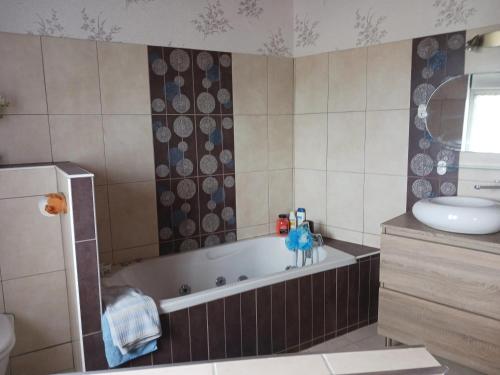 une salle de bain avec une baignoire et un lavabo dans l'établissement Maison avec jardin à Réville, 80 m², 6 personnes, à Réville