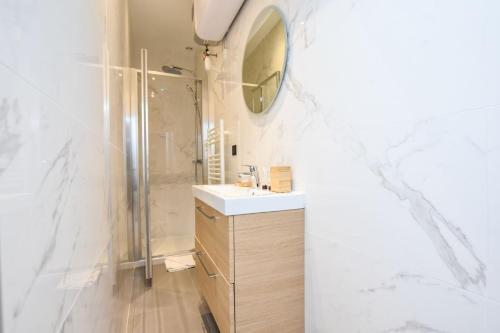 une salle de bain avec une douche, un lavabo et un miroir dans l'établissement Duplex agréable Paris 20ᵉ - Belleville, à Paris