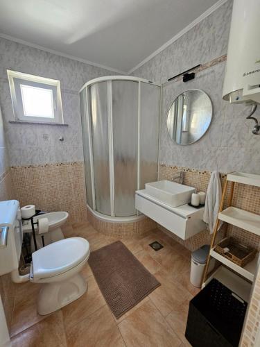 a bathroom with a shower and a toilet and a sink at Apartmani M&L in Medulin