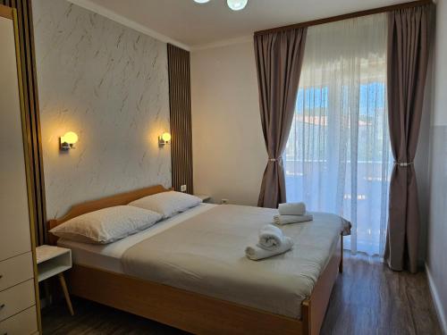 a bedroom with a large bed with towels on it at Apartmani M&L in Medulin