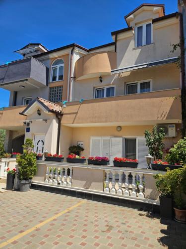 a large house with flowers on a brick driveway at Apartmani M&L in Medulin