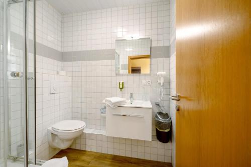 a bathroom with a toilet and a sink and a mirror at Bed and Breakfast St Wendel in Prüm