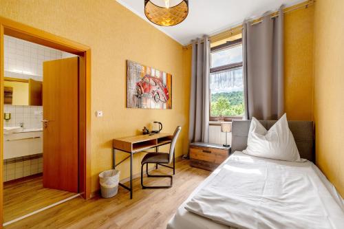 a bedroom with a bed and a desk and a kitchen at Bed and Breakfast St Wendel in Prüm