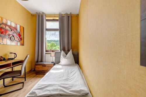 a bedroom with a bed and a desk and a window at Bed and Breakfast St Wendel in Prüm