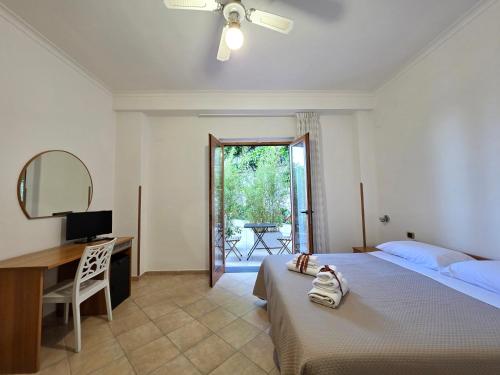 a bedroom with a bed and a desk and a mirror at Oasi Relais in Vico Equense