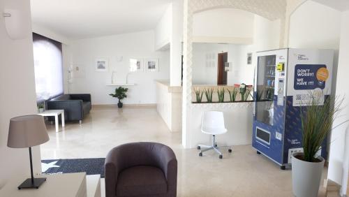 een kantoor met een lobby met stoelen en een verkoopautomaat bij RocaBelmonte in Albufeira