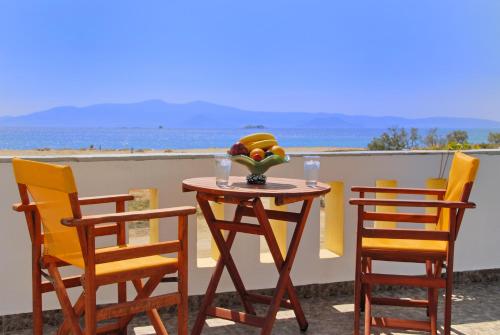 a table and chairs with a bowl of fruit on a balcony at Sea Melody Studios in Plaka