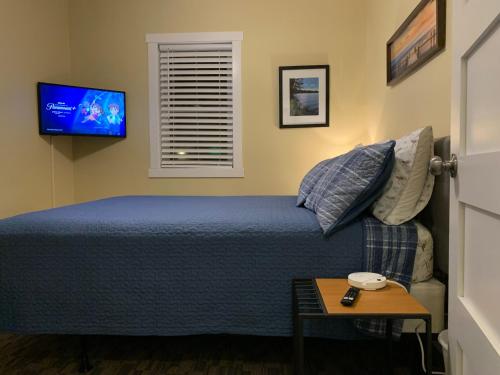 una camera da letto con un letto e una TV a parete di Cottage11 of Avalon -2 Bedroom-1 Bath- Laundry- Sleeps 6 a Lansing