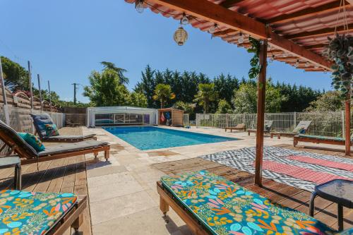 a swimming pool with lounge chairs and a patio at Gite du Parc in Genouillé