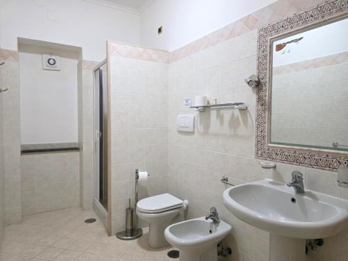 a bathroom with a sink and a toilet and a mirror at Oasi Relais in Vico Equense