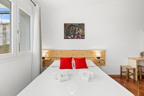 a bedroom with a white bed with red pillows at Sa Stadda in Lanusei