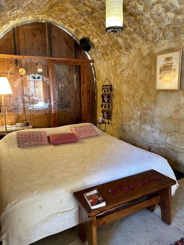 a bedroom with a large bed and a table at Beit Faris Wa Lucia Guesthouse Byblos in Jbeil