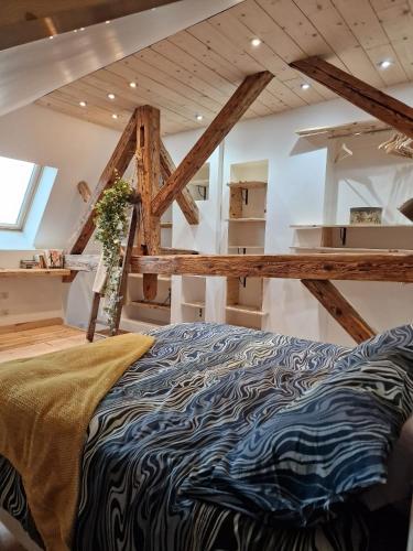 Cette chambre dispose d'un grand lit et de poutres apparentes. dans l'établissement Duplex la Beun, à Saint-Paul-en-Chablais