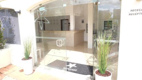 un front de magasin avec deux plantes en pot dans une fenêtre dans l'établissement RocaBelmonte, à Albufeira
