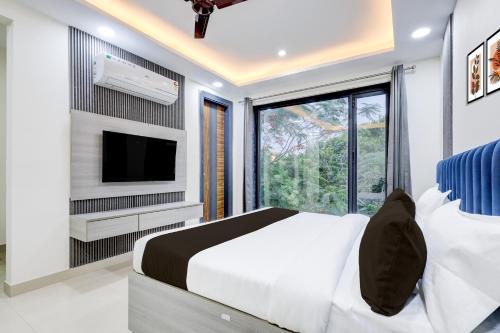 a bedroom with a bed and a tv and a window at The Byke Business Hotel - Sector 29 in Gurgaon