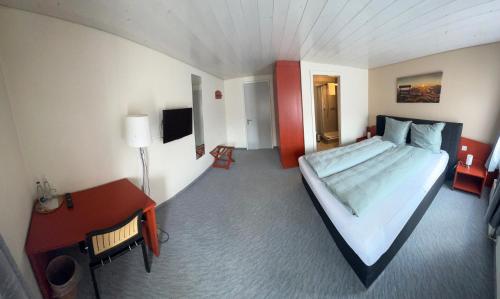 ein Schlafzimmer mit einem großen Bett und einem Schreibtisch in der Unterkunft Gasthof zum Schweizerhaus in Ricken