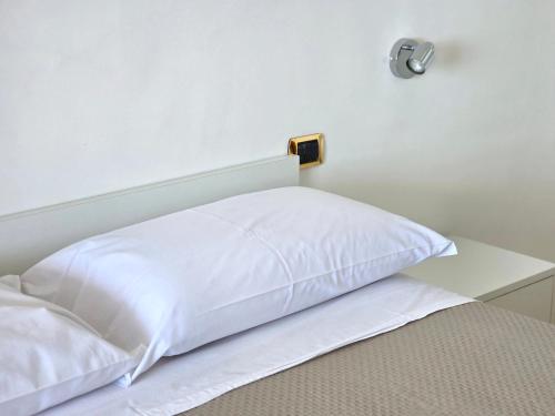 a bed with a white pillow on top of it at Oasi Relais in Vico Equense