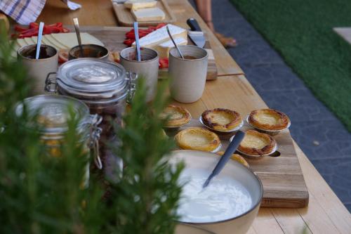 een houten tafel met borden met eten erop bij SURFinn Lisbon in Costa da Caparica