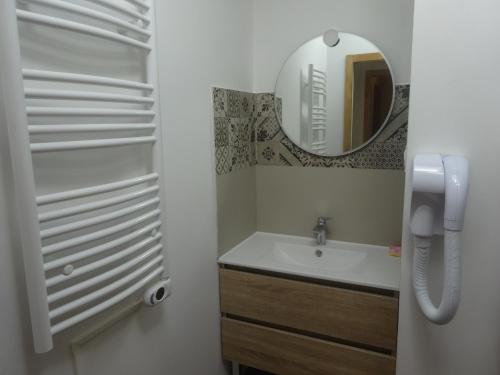 une salle de bain avec un lavabo et un miroir dans l'établissement Gite provençal de Montigal, à Bagnols-sur-Cèze