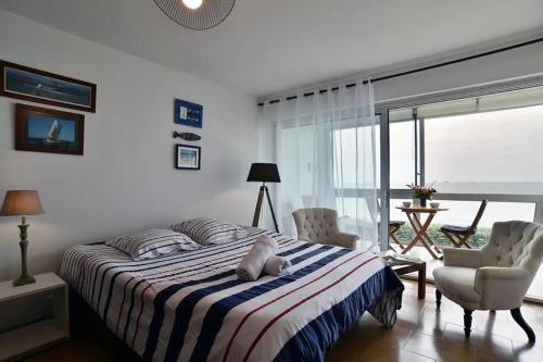 une chambre avec un grand lit et deux chaises dans l'établissement Le grand jardin, à Saint-Malo