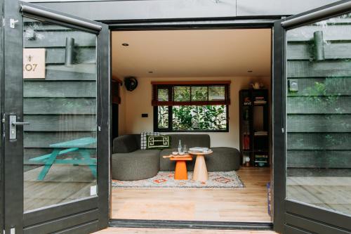 an open door into a living room with a table at Bumblebee Cabin in Diessen