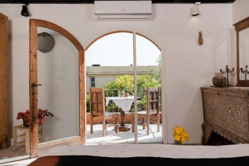 an archway in a room with a table and chairs at Beit Faris Wa Lucia Guesthouse Byblos in Jbeil