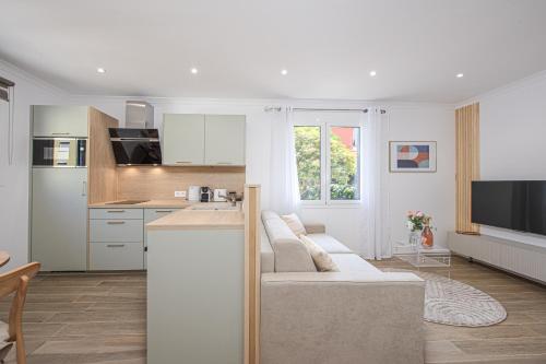 un salon avec un canapé et une cuisine dans l'établissement ORCHIDÉES II - SUPERBE 2 Pièces - 50 m BORD DE MER, à Roquebrune-Cap-Martin