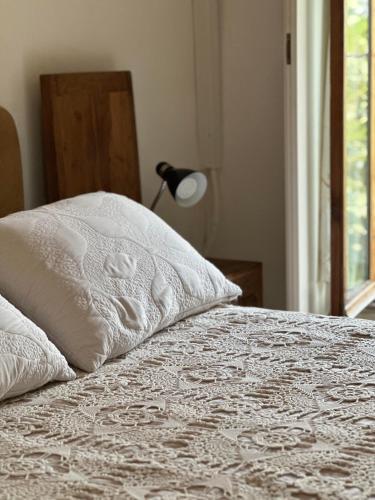 a bed with a pillow and a lamp and a window at Beit Faris Wa Lucia Guesthouse Byblos in Jbeil