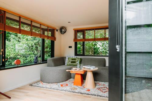 a living room with a couch and a table at Bumblebee Cabin in Diessen