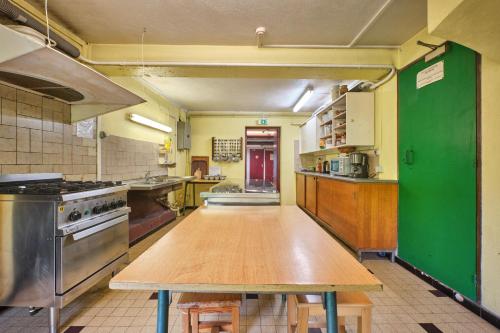 une grande cuisine avec une table en bois. dans l'établissement Chalet de l'ulmjc de Grenoble, à La Morte