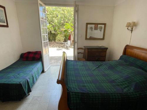 une chambre avec deux lits et une porte donnant sur une cour dans l'établissement Maison 5 pièces 8 couchages ARGELES SUR MER AR000-070, à Argelès-sur-Mer