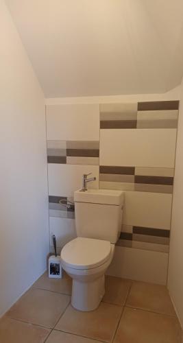 une salle de bain avec des toilettes blanches dans une chambre dans l'établissement Chambres Campagne 1 et 2, à Le Mesnil-Guillaume