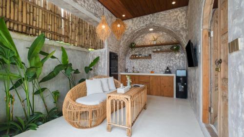 een woonkamer met een rieten stoel en een tafel bij Nick Villas by Villa Finder in Ubud