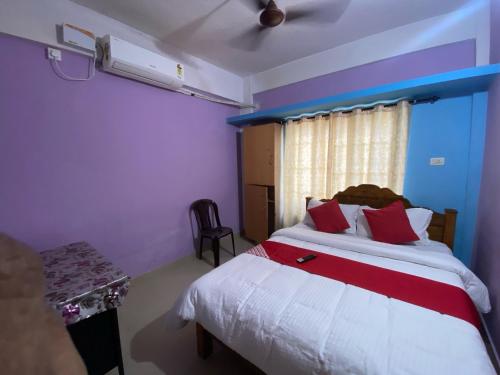 Un dormitorio con una cama con almohadas rojas y una ventana. en Hotel O Siva Karthika, en Trivandrum