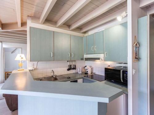 une cuisine avec des placards verts et un comptoir dans l'établissement Duplex pied de pistes, 8 pers, 2 chambres, balcon sud, parking, station centrale - FR-1-404-337, à La Mongie