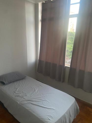 a bed in a bedroom with a window at Apartamento no centro de Uberlândia in Uberlândia