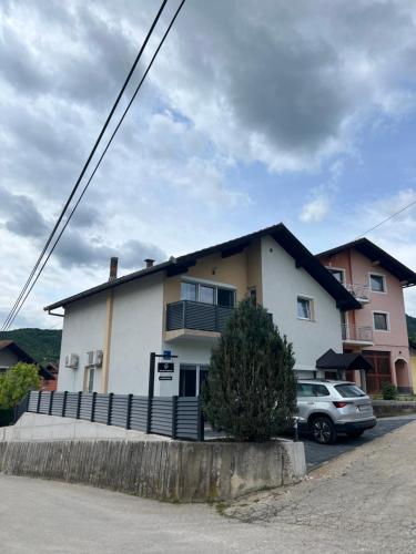 a white house with a car parked in front of it at Home Away From Home in Jajce