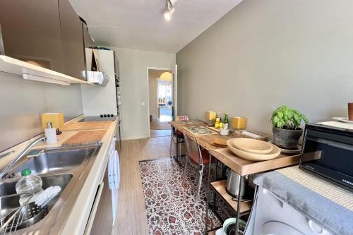 une cuisine avec une table et un comptoir dans l'établissement Apartment for 2 with balcony - near park, à Vallauris