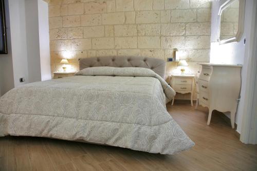 1 dormitorio con 1 cama grande y 2 mesitas de noche en L'Angolo del Salento, en Oria