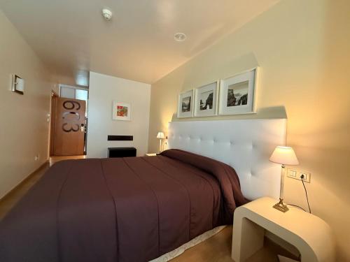 a bedroom with a large bed and two pictures on the wall at Hotel Bouza in Ribadeo